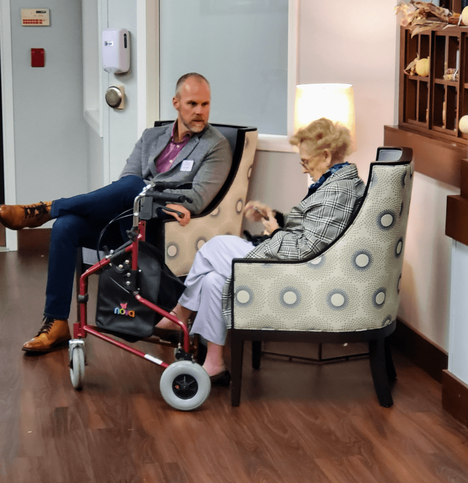 Joe Comly speaking with a resident in a home care setting.
